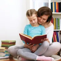Mother and daughter reading on floor